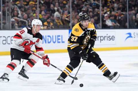 Apr 8, 2023; Boston, Massachusetts, USA; Boston Bruins center Patrice Bergeron (37) controls the puck while New Jersey Devils left wing Ondrej Palat (18) defends during the third period at TD Garden. Mandatory Credit: Bob DeChiara-USA TODAY Sports