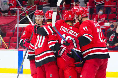 Apr 6, 2021; Raleigh, North Carolina, USA; Carolina Hurricanes center Vincent Trocheck (16) is congratulated by center Jordan Staal (11) right-wing Sebastian Aho (20), and defenseman Dougie Hamilton (19) after his third-period goal against the Florida Panthers at PNC Arena. Mandatory Credit: James Guillory-USA TODAY Sports