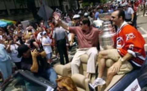 RALEIGH, NC – JUNE 21: Coach Peter Laviolette (L) and Bret Hedican #6 of the Carolina Hurricanes ride with the Stanley Cup during a “Hail To Our Champions” parade to celebrate the team’s Stanley Cup victory over the Edmonton Oilers June 21, 2006, in Raleigh, North Carolina. (Photo by Grant Halverson/Getty Images)