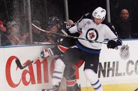 NEW YORK, NY – NOVEMBER 06: Blake Wheeler #26 of the Winnipeg Jets hits Michael Del Zotto #4 of the New York Rangers into the boards at Madison Square Garden on November 6, 2011 in New York City. The Rangers defeated the Jets 3-0. (Photo by Bruce Bennett/Getty Images)