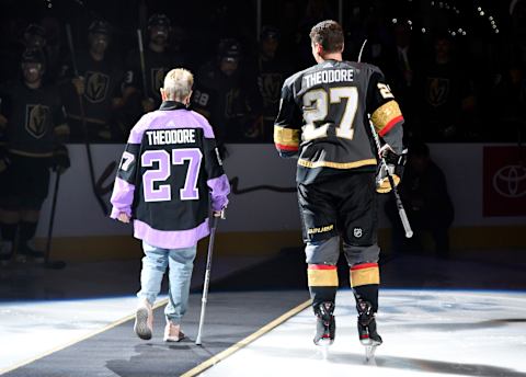 LAS VEGAS, NEVADA – NOVEMBER 21: Shea Theodore #27 of the Vegas Golden Knights escorts his grandmother Kay Darlington off the ice after performing the ceremonial puck drop prior to a game against the San Jose Sharks at T-Mobile Arena on November 21, 2019 in Las Vegas, Nevada. (Photo by Jeff Bottari/NHLI via Getty Images)