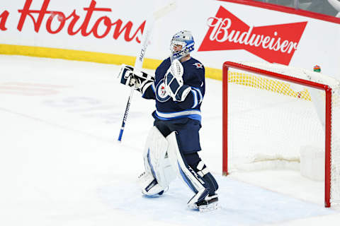 Apr 27, 2022; Winnipeg, Manitoba, CAN; Winnipeg Jets goalie Eric Comrie (1) celebrates their win against the Philadelphia Flyers at the end of the third period at Canada Life Centre. Mandatory Credit: Terrence Lee-USA TODAY Sports