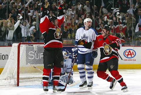 KANATA, ON – APRIL 18: Mike Fischer #12 of the Ottawa Senators raises his hands after scoring the game winning goal in double overtime during game six of the Eastern Conference Quarterfinals at the Corel Centre on April 18, 2004 in Kanata, Ontario. Teammate Chris Neil #25 goes to congratulate him as Ed Belfour #20 and Bryan Marchment #27 of the Toronto Maple Leafs look dejected. The Senators won the game 2-1 in double overtime to tie the series 3-3. (Photo By Dave Sandford/Getty Images)