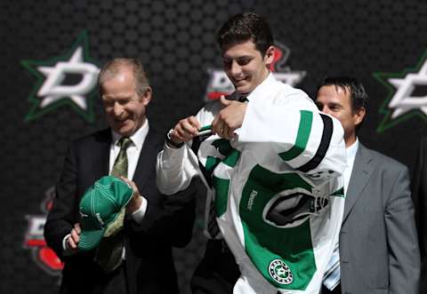 Jun 30, 2013; Newark, NJ, USA; Jason Dickinson puts on a team jersey after being introduced as the number twenty-nine overall pick to the Dallas Stars during the 2013 NHL Draft at the Prudential Center. Mandatory Credit: Ed Mulholland-USA TODAY Sports