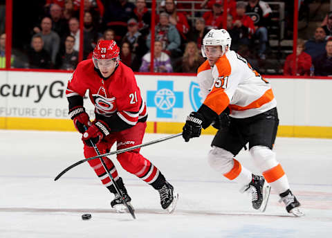 RALEIGH, NC – FEBRUARY 6: Sebastian Aho #20 of the Carolina Hurricanes and Valtteri Filuppa #51 of the Philadelphia Flyers battle to control the puck during an NHL game on February 6, 2018 at PNC Arena in Raleigh, North Carolina. (Photo by Gregg Forwerck/NHLI via Getty Images)