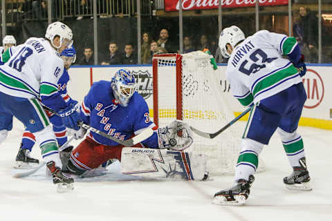 NEW YORK, NY – NOVEMBER 12: New York Rangers goaltender Henrik Lundqvist (30) makes save on shot by Vancouver Canucks center Bo Horvat (53) as Vancouver Canucks right wing Jake Virtanen (18) looks for rebound during the Vancouver Canucks and New York Rangers NHL game on November 12, 2018, at Madison Square Garden in New York, NY. (Photo by John Crouch/Icon Sportswire via Getty Images)