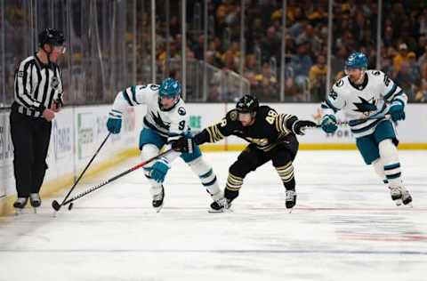 BOSTON, MASSACHUSETTS – NOVEMBER 30: Jacob MacDonald #9 of the San Jose Sharks and Matt Grzelcyk #48 of the Boston Bruins battle for control of the puck during the second period at TD Garden on November 30, 2023, in Boston, Massachusetts. (Photo by Maddie Meyer/Getty Images)