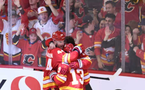 May 15, 2022; Calgary, Alberta, CAN; Calgary Flames defenseman Erik Gudbranson (44) forward Johnny Gaudreau (13) and forward Matthew Tkachuk (19) celebrate the overtime win over the Dallas Stars in game seven of the first round of the 2022 Stanley Cup Playoffs at Scotiabank Saddledome. Mandatory Credit: Candice Ward-USA TODAY Sports