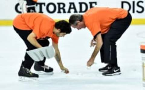 Apr 18, 2016; Philadelphia, PA, USA; Members of the Philadelphia Flyers Ice Crew pick up wristband that were thrown onto the ice during the third period against the Washington Capitals in game three of the first round of the 2016 Stanley Cup Playoffs at Wells Fargo Center. The Capitals defeated the Flyers, 6-1. Mandatory Credit: Eric Hartline-USA TODAY Sports