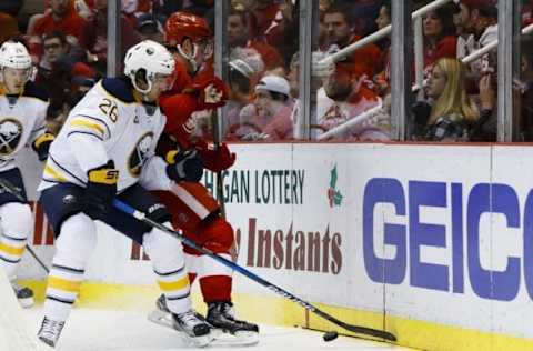 Dec 27, 2016; Detroit, MI, USA; Buffalo Sabres left wing Matt Moulson (26) and Detroit Red Wings center Dylan Larkin (71) battle for the puck in the third period at Joe Louis Arena. Buffalo won 4-3. Mandatory Credit: Rick Osentoski-USA TODAY Sports