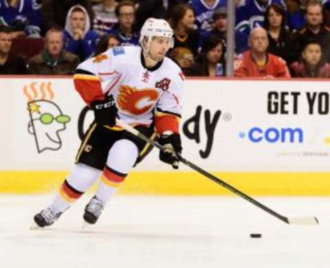 Feb 6, 2016; Vancouver, British Columbia, CAN; Calgary Flames defenseman Kris Russell (4) controls the puck against the Vancouver Canucks during the first period at Rogers Arena. The Calgary Flames won 4-1. Mandatory Credit: Anne-Marie Sorvin-USA TODAY Sports