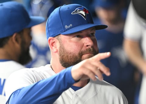 Jul 13, 2022; Toronto, Ontario, CAN; Toronto Blue Jays interim manager John Schneider (21) gestures at fans from the dugout before the game against the Philadelphia Phillies at Rogers Centre. Mandatory Credit: Dan Hamilton-USA TODAY Sports