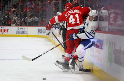 DETROIT, MICHIGAN – OCTOBER 12: Auston Matthews #34 of the Toronto Maple Leafs takes a check from Luke Glendening #41 of the Detroit Red Wings during the third period at Little Caesars Arena on October 12, 2019 in Detroit, Michigan. Toronto won the game 5-2. (Photo by Gregory Shamus/Getty Images)