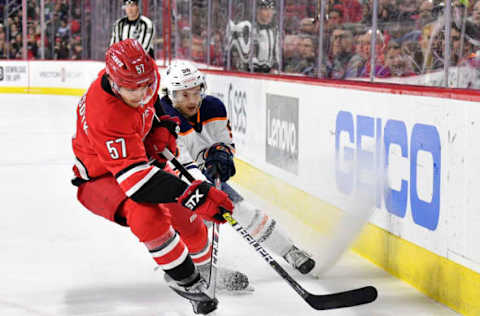 RALEIGH, NORTH CAROLINA – FEBRUARY 16: Trevor van Riemsdyk #57 of the Carolina Hurricanes battles Kailer Yamamoto #56 of the Edmonton Oilers for the puck during the first period of their game at PNC Arena on February 16, 2020 in Raleigh, North Carolina. (Photo by Grant Halverson/Getty Images)