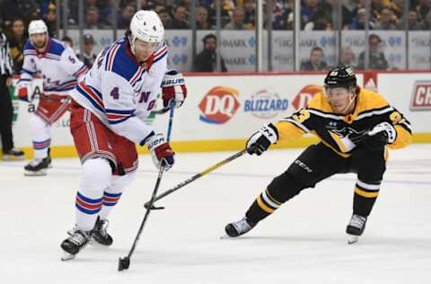 PITTSBURGH, PA – DECEMBER 20: Braden Schneider #4 of the New York Rangers moves the puck under pressure from Brock McGinn #23 of the Pittsburgh Penguins in the third period during the game at PPG PAINTS Arena on December 20, 2022, in Pittsburgh, Pennsylvania. (Photo by Justin Berl/Getty Images)