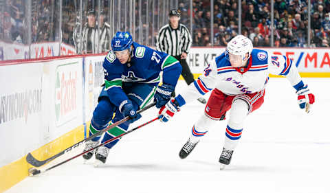 VANCOUVER, BC – NOVEMBER 2: Travis Hamonic #27 of the Vancouver Canucks tries to get past Kaapo Kakko #24 of the New York Rangers during NHL action on November 2, 2021 at Rogers Arena in Vancouver, British Columbia, Canada. (Photo by Rich Lam/Getty Images)