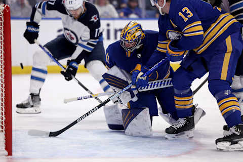 Mar 30, 2022; Buffalo, New York, USA; Buffalo Sabres goaltender Craig Anderson (41) watches as defenseman Mark Pysyk (13) clears the puck from the crease during the first period against the Winnipeg Jets at KeyBank Center. Mandatory Credit: Timothy T. Ludwig-USA TODAY Sports