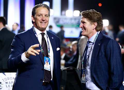 VANCOUVER, BRITISH COLUMBIA - JUNE 22: President Brendan Shanahan (L) and head coach Mike Babcock of the Toronto Maple Leafs talk on the draft floor during Rounds 2-7 of the 2019 NHL Draft at Rogers Arena on June 22, 2019 in Vancouver, Canada. (Photo by Jeff Vinnick/NHLI via Getty Images)