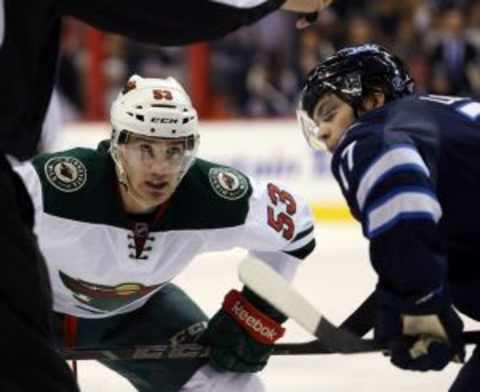 Dec 29, 2014; Winnipeg, Manitoba, CAN; Winnipeg Jets forward Adam Lowry (17) faces off against Minnesota Wild forward Tyler Graovac (53) during the third period at MTS Centre. The Wild won 3-2. Mandatory Credit: Bruce Fedyck-USA TODAY Sports