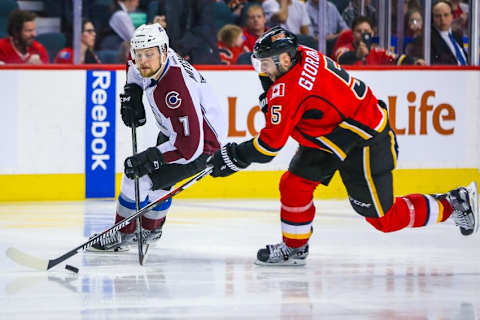 Mar 18, 2016; Calgary, Alberta, CAN; Colorado Avalanche center John Mitchell (7) and Calgary Flames defenseman Mark Giordano (5) battle for the puck during the third period at Scotiabank Saddledome. Colorado Avalanche won 4-3. Mandatory Credit: Sergei Belski-USA TODAY Sports