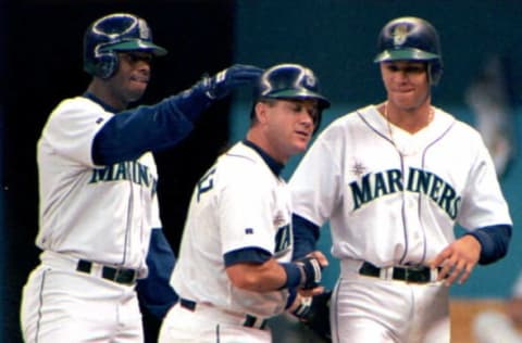 SEATTLE, UNITED STATES: Seattle Mariners’ Edgar Martinez(C) grimaces after he is congratulated by teammates Ken Griffey, Jr.(L) and Alex Rodriguez(R) after Martinez hit a first inning, three-run homer, against the New York Yankees in Seattle 26 May. Seattle defeated New York, 4-3. AFP PHOTO (Photo credit should read DAN LEVINE/AFP/Getty Images)