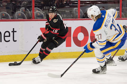 Jan 25, 2022; Ottawa, Ontario, CAN; Ottawa Senators left wing Tim Stützle (18) skates with the puck in front of Buffalo Sabres center Casey Mittelstadt (37) in the first period at the Canadian Tire Centre. Mandatory Credit: Marc DesRosiers-USA TODAY Sports