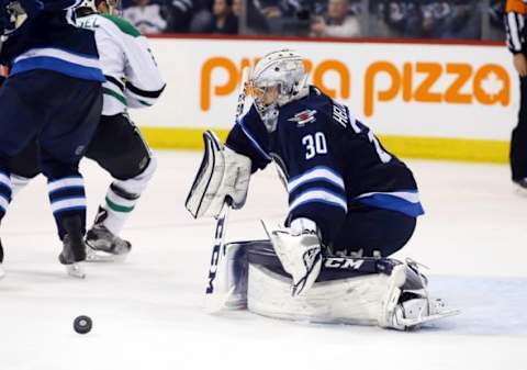 Feb 2, 2016; Winnipeg, Manitoba, CAN; Winnipeg Jets goalie Connor Hellebuyck (30) makes a save during the third period against the Dallas Stars at the MTS Centre. Dallas wins 5-3. Mandatory Credit: Bruce Fedyck-USA TODAY Sports