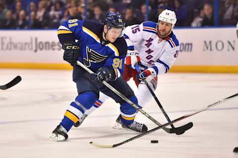 Feb 25, 2016; St. Louis, MO, USA; New York Rangers left wing Tanner Glass (15) reaches for the puck on St. Louis Blues right wing Vladimir Tarasenko (91) during the second period at Scottrade Center. Mandatory Credit: Jasen Vinlove-USA TODAY Sports