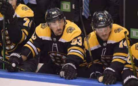 Aug 26, 2020; Toronto, Ontario, CAN; Boston Bruins left wing Brad Marchand (63) and right wing Chris Wagner (14) react on the bench during the third period against the Tampa Bay Lightning in game three of the second round of the 2020 Stanley Cup Playoffs at Scotiabank Arena. Mandatory Credit: Dan Hamilton-USA TODAY Sports