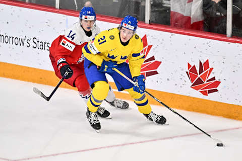 HALIFAX, CANADA – JANUARY 04: Leo Carlsson #21 of Team Sweden skates the puck against Stanislav Svozil #14 of Team Czech Republic during overtime in the semifinal round of the 2023 IIHF World Junior Championship at Scotiabank Centre on January 4, 2023 in Halifax, Nova Scotia, Canada. Team Czech Republic defeated Team Sweden 2-1 in overtime. (Photo by Minas Panagiotakis/Getty Images)