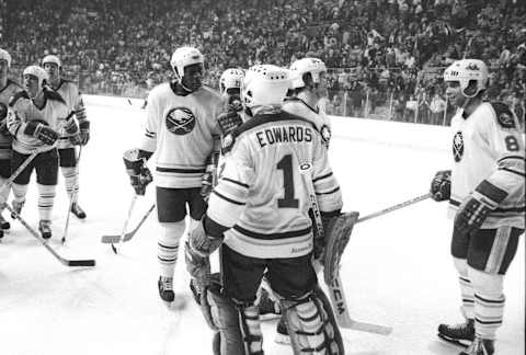 BUFFALO, NY – 1982: Val James #26, Don Edwards #1 and Tony McKegney #8 of the Buffalo Sabres celebrate following a 5-2 win over the Boston Bruins in Game 3 of the Adams Division semi-final on April 10, 1982 at Memorial Auditorium in Buffalo, NY. (Photo by Bill Wippert/Getty Images)