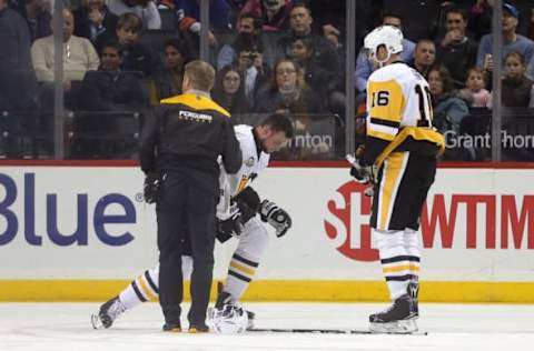 Nov 18, 2016; Brooklyn, NY, USA; Pittsburgh Penguins defenseman Brian Dumoulin (8) is helped off the ice after an injury during the first period against the New York Islanders at Barclays Center. Mandatory Credit: Brad Penner-USA TODAY Sports