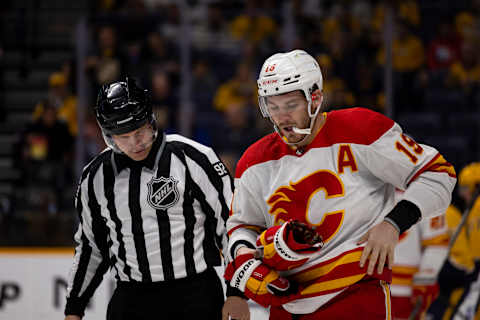 NASHVILLE, TN – APRIL 19: Matthew Tkachuk #19 of the Calgary Flames is escorted to the penalty box during the second period against the Nashville Predators at Bridgestone Arena on April 19, 2022 in Nashville, Tennessee. (Photo by Brett Carlsen/Getty Images)