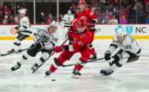 Jan 31, 2023; Raleigh, North Carolina, USA; Carolina Hurricanes defenseman Calvin de Haan (44) is chased by Los Angeles Kings center Blake Lizotte (46) and center Jaret Anderson-Dolan (28) during the second period at PNC Arena. Mandatory Credit: James Guillory-USA TODAY Sports