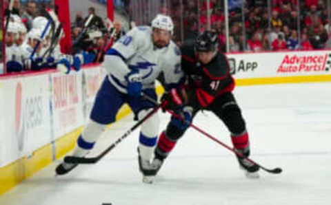 Mar 28, 2023; Raleigh, North Carolina, USA; Tampa Bay Lightning left wing Nicholas Paul (20) and Carolina Hurricanes defenseman Shayne Gostisbehere (41) battle for the puck during the second period at PNC Arena. Mandatory Credit: James Guillory-USA TODAY Sports