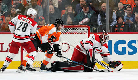 PHILADELPHIA, PA – APRIL 05: Sean Couturier #14 of the Philadelphia Flyers battles for the puck on a scoring attempt against Scott Darling #33 and Elias Lindholm #28 of the Carolina Hurricanes on April 5, 2018 at the Wells Fargo Center in Philadelphia, Pennsylvania. (Photo by Len Redkoles/NHLI via Getty Images)