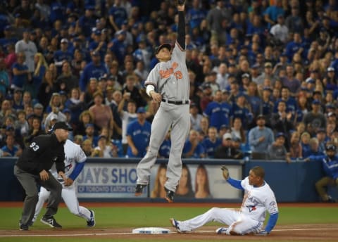 Sep 28, 2016; Toronto, Ontario, CAN; Toronto Blue Jays left fielder Ezequiel Carrera (3) slides safely into third as Baltimore Orioles third baseman Manny Machado (13) leaps for a high throw in the first inning at Rogers Centre. Mandatory Credit: Dan Hamilton-USA TODAY Sports