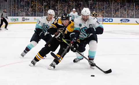 BOSTON, MA – FEBRUARY 1: Brad Marchand, #63 of the Boston Bruins, checks Mark Giordano, #5 of the Seattle Kraken, during the third period at the TD Garden on February 1, 2022, in Boston, Massachusetts. The Bruins won 3-2. (Photo by Rich Gagnon/Getty Images)