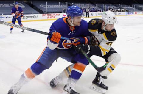 UNIONDALE, NEW YORK – JANUARY 18: Ryan Pulock #6 of the New York Islanders and Jake DeBrusk #74 of the Boston Bruins pursue the puck during the first period at Nassau Coliseum on January 18, 2021 in Uniondale, New York. (Photo by Bruce Bennett/Getty Images)