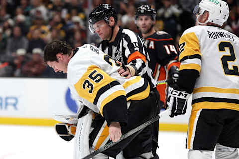 ANAHEIM, CALIFORNIA – NOVEMBER 07: Referee Trevor Hanson escorts Tristan Jarry #35 of the Pittsburgh Penguins off the ice after an injury during the second period of a game against the Anaheim Ducks at Honda Center on November 07, 2023 in Anaheim, California. (Photo by Sean M. Haffey/Getty Images)