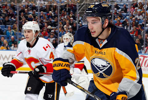 BUFFALO, NY – DECEMBER 14: Zemgus Girgensons #28 of the Buffalo Sabres and Kris Russell #4 of the Calgary Flames follow the play at First Niagara Center on December 14, 2013 in Buffalo, New York. Calgary defeated Buffalo 2-1. (Photo by Jen Fuller/Getty Images)