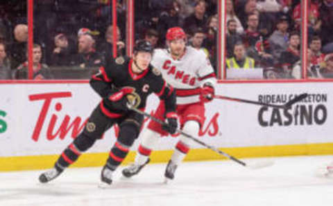 Apr 10, 2023; Ottawa, Ontario, CAN; Ottawa Senators left wing Brady Tkacuk (7) and Carolina Hurricanes defenseman Brett Pesce (22) chase the puck in the first period at the Canadian Tire Centre. Mandatory Credit: Marc DesRosiers-USA TODAY Sports