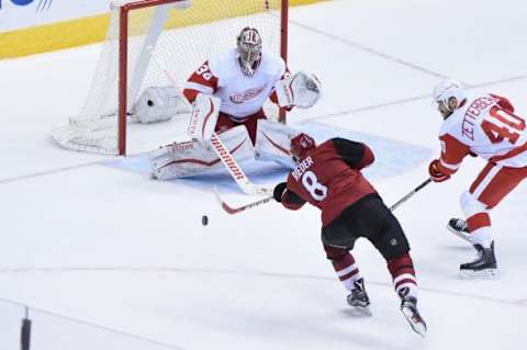 Jan 14, 2016; Glendale, AZ, USA; Arizona Coyotes center Tobias Rieder (8) shoots the puck on Detroit Red Wings goalie Petr Mrazek (34) as left wing Henrik Zetterberg (40) defends during the third period at Gila River Arena. Mandatory Credit: Matt Kartozian-USA TODAY Sports