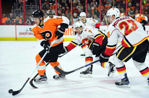 Nov 27, 2016; Philadelphia, PA, USA; Philadelphia Flyers center Travis Konecny (11) carries the puck against defenseman TJ Brodie (7) and Calgary Flames center Sean Monahan (23) during the second period at Wells Fargo Center. Mandatory Credit: Eric Hartline-USA TODAY Sports