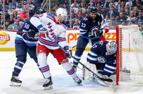 WINNIPEG, MB – FEBRUARY 12: Goaltender Connor Hellebuyck #37 of the Winnipeg Jets covers up the puck in the crease as Kevin Hayes #13 of the New York Rangers looks for a rebound during third period action at the Bell MTS Place on February 12, 2019 in Winnipeg, Manitoba, Canada. (Photo by Jonathan Kozub/NHLI via Getty Images)