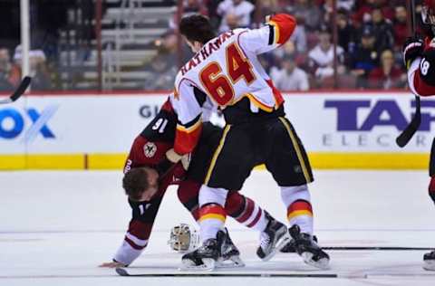 Dec 8, 2016; Glendale, AZ, USA; Calgary Flames right wing Garnet Hathaway (64) punches Arizona Coyotes left wing Max Domi (16) during the second period at Gila River Arena. Mandatory Credit: Matt Kartozian-USA TODAY Sports