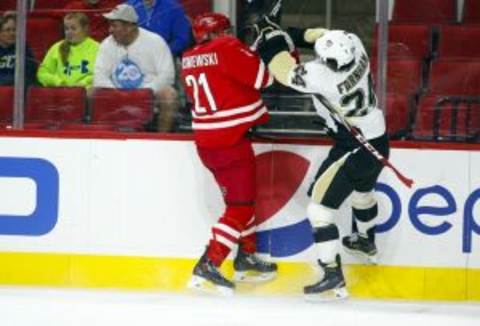 Oct 2, 2015; Raleigh, NC, USA; Pittsburgh Penguins forward Bobby Farnham (24) checks the Carolina Hurricanes defensemen James Wisniewski (21) during the 1st period at PNC Arena. Mandatory Credit: James Guillory-USA TODAY Sports