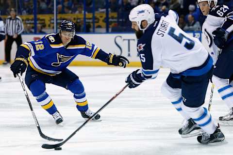 Apr 4, 2017; St. Louis, MO, USA; St. Louis Blues center Jori Lehtera (12) reaches to clear the puck from Winnipeg Jets defenseman Mark Stuart (5) during the second period at Scottrade Center. Mandatory Credit: Scott Kane-USA TODAY Sports