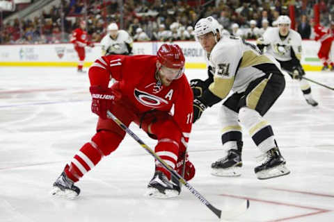 Feb 12, 2016; Raleigh, NC, USA; Carolina Hurricanes forward Jordan Staal (11) skates with the puck past Pittsburgh Penguins defenseman Derek Pouliot (51) during the second period at PNC Arena. Mandatory Credit: James Guillory-USA TODAY Sports