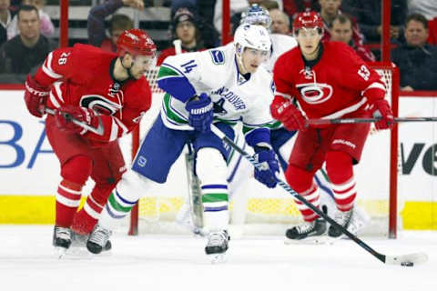 Jan 16, 2015; Raleigh, NC, USA; Vancouver Canucks forward Alexandre Burrows (14) clears out the puck in front of the net against the Carolina Hurricanes at PNC Arena. The Vancouver Canucks defeated the Carolina Hurricanes 3-0. Mandatory Credit: James Guillory-USA TODAY Sports